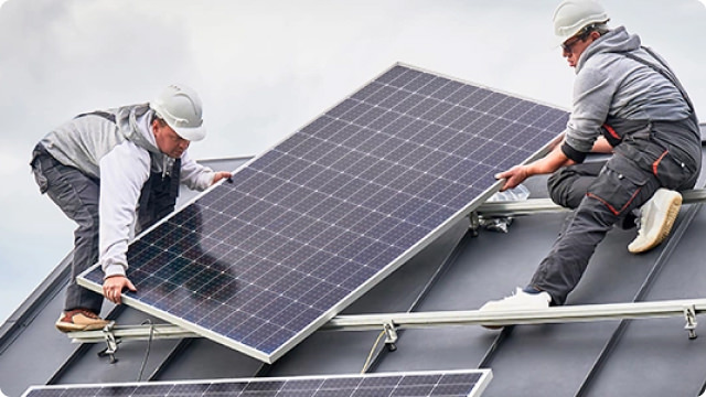 two colleagues putting solar panel on roof