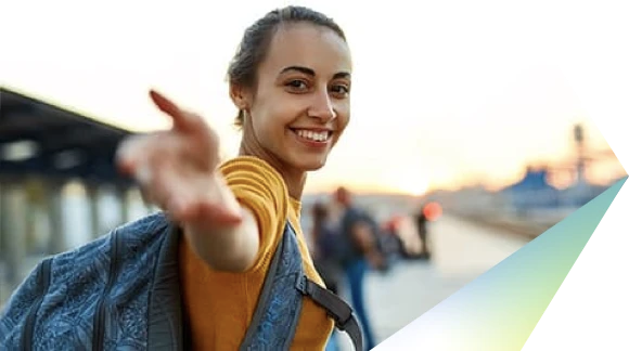 Woman in yellow blouse, smiling and reaching out her right hand towards the camera