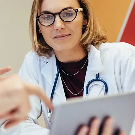 A medical professional looking at a tablet