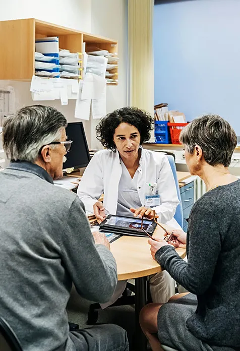 doctor talking to two people