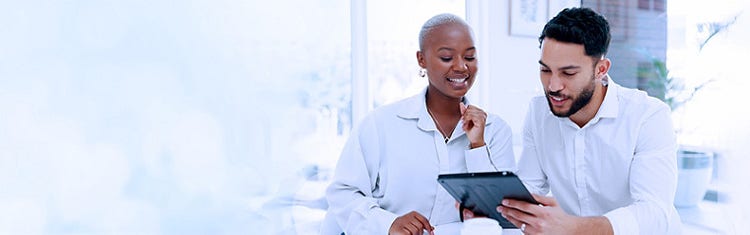 A young lady and a man discussing something by looking at the tablet on their hand